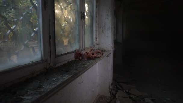 Juguete viejo en un alféizar de ventana en una casa abandonada en Chernobyl Ucrania. Concepto post apocalíptico. Enfoque selectivo - Metraje, vídeo