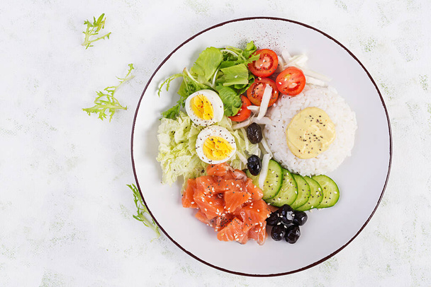 Salade de saumon bio frais avec riz, œuf bouilli, tomates, concombre et olives noires. Restauration rapide et saine, déjeuner, concept de nutrition. Vue de dessus, plan plat - Photo, image