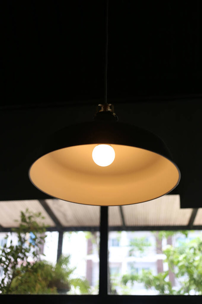 Vintage zwarte lantaarn in een restaurant met lampjes aan. - Foto, afbeelding