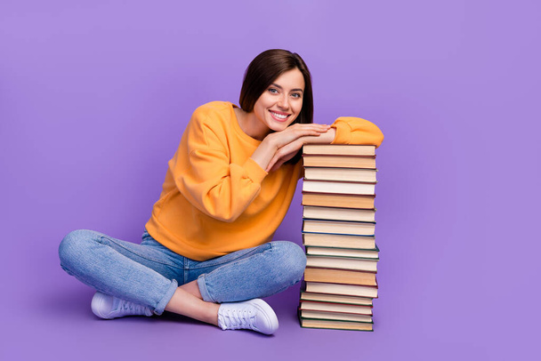 Full body length photo of young dreamy positive girl sitting crossed legs lovely touch her home library pile books nerd isolated on purple color background. - Foto, Imagen