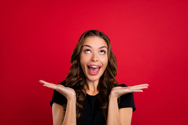 Photo of young excited girl look empty space curious unexpected news discount isolated over red color background. - Foto, imagen