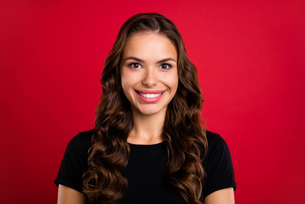 Photo of sweet charming young lady dressed black t-shirt smiling showing teeth isolated red color background. - Zdjęcie, obraz