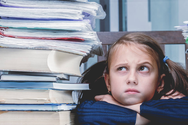 Conceptual portrait of angry and exhausted young female employee working overtime alone in office with large amount of documents without cariere perspective and additional payments. Copy space. - 写真・画像