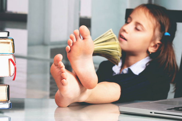 Portrait of very happy cute young business girl counts money profit. Selective focus on bare feet - Valokuva, kuva