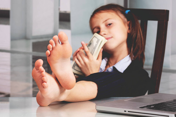 Retrato de muito feliz bonito menina de negócios com os pés descalços sobre a mesa e conta lucro dinheiro. Foco seletivo. - Foto, Imagem