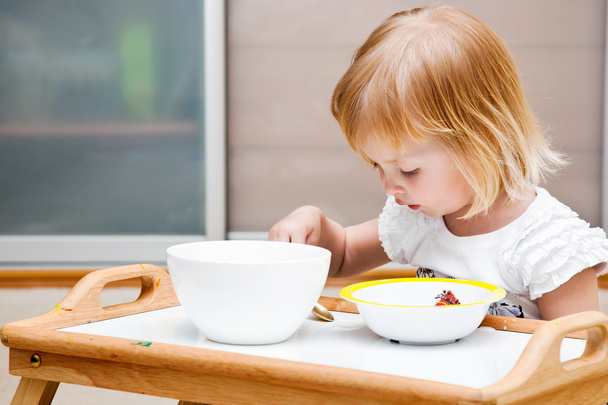 A small girl is eating - Фото, зображення