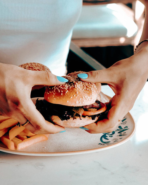 Finom hamburger grillezett marhahússal, zöldségekkel, szósszal. Gyorsétterem és gyorsétterem koncepció. - Fotó, kép