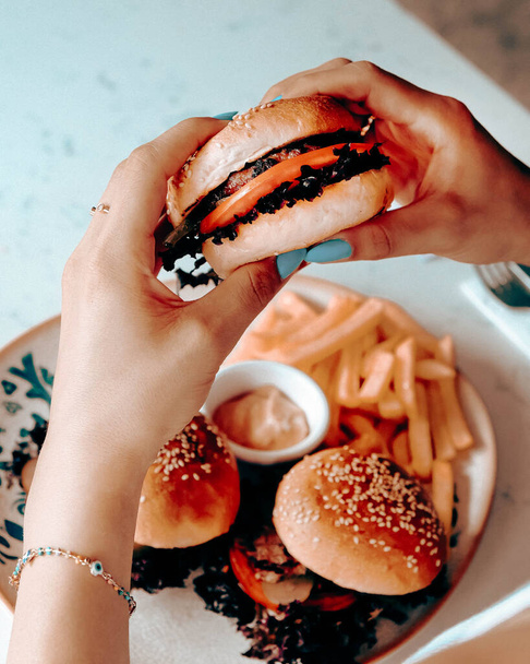 Heerlijke hamburger met gegrild rundvlees, groenten, saus. Fast food en junk food concept. - Foto, afbeelding