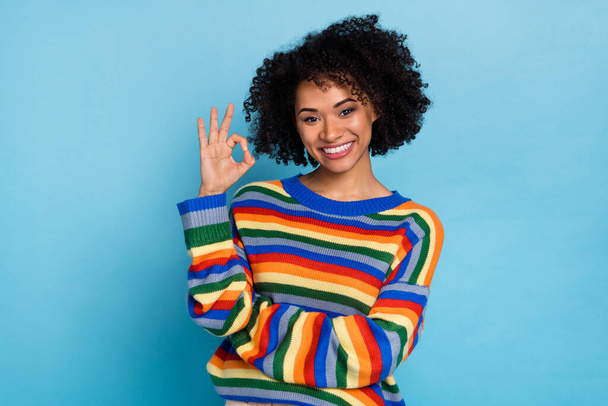 Photo of young short hairdo lady show okey wear colorful pullover isolated on blue color background. - Φωτογραφία, εικόνα