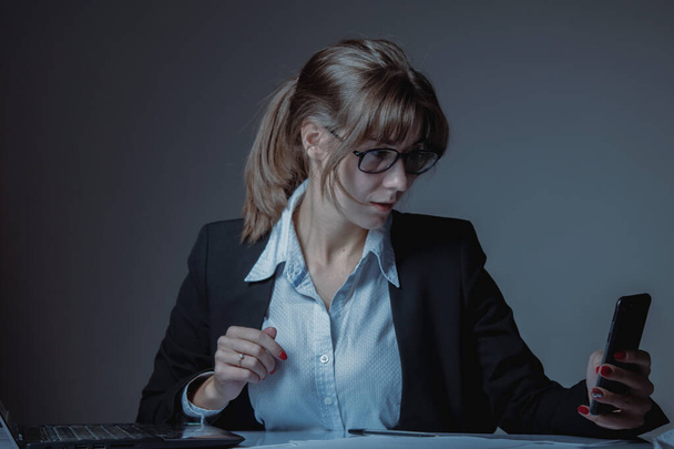 Conceptual image: Unprofessional behavior. A business woman is distracted from work through private messages or personal correspondence on the phone. - Fotó, kép