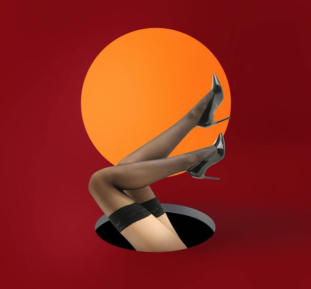 Las piernas de la hermosa mujer joven en medias negras sobre fondo de color - Foto, imagen
