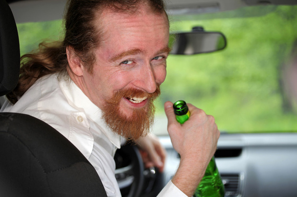 Μεθυσμένος άντρας στο αυτοκίνητο με ένα μπουκάλι αλκοόλ - Φωτογραφία, εικόνα