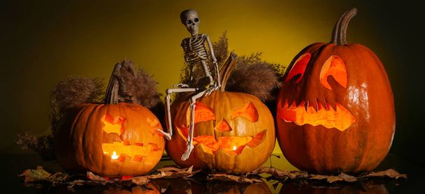 Вырезанный Хэллоуин тыквы со скелетом на темном фоне - Фото, изображение