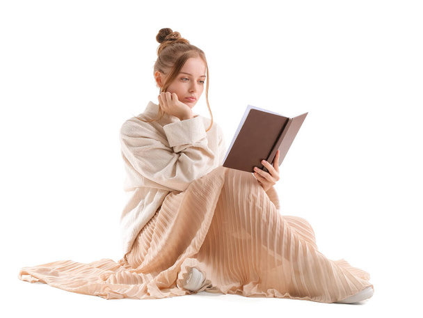 Sad young woman reading book on white background - Photo, Image