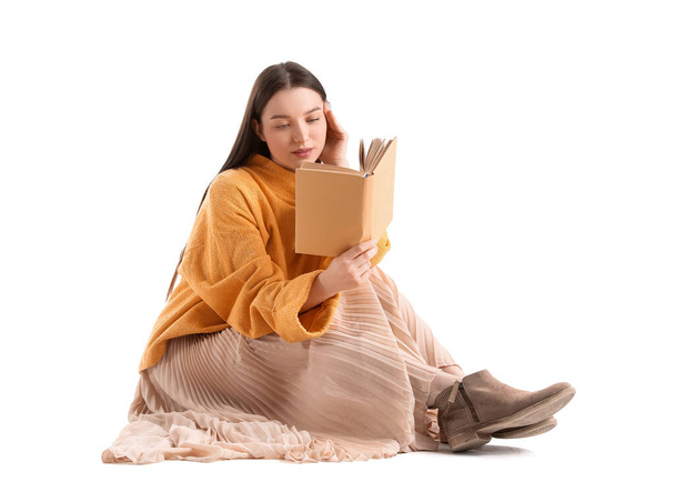 Beautiful woman in yellow sweater reading book on white background - Photo, Image