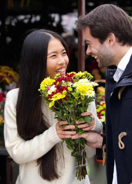 Homme heureux donnant des fleurs à une femme souriante
 - Photo, image