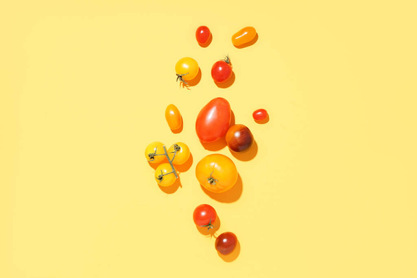 Different ripe tomatoes on yellow background - Photo, Image