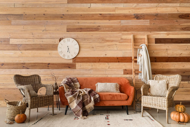Интерьер стильной гостиной с красным диваном, креслами и тыквами - Фото, изображение