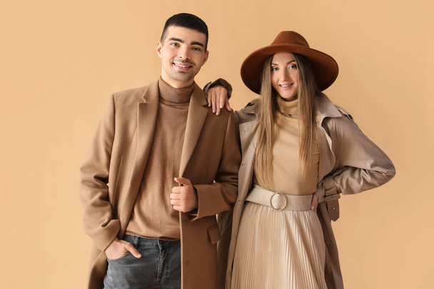 流行の若いカップルで秋の服でベージュの背景 - 写真・画像