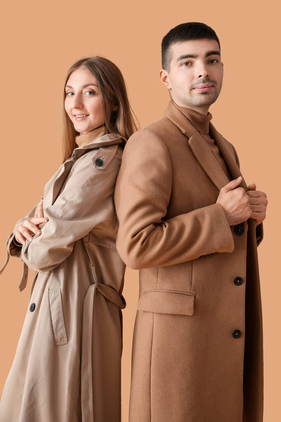 Bej arka planda sonbahar kıyafetleri içinde şık genç bir çift. - Fotoğraf, Görsel