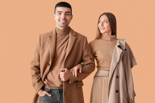 Jeune couple à la mode en vêtements d'automne sur fond beige - Photo, image