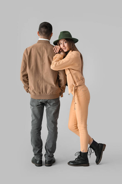 Jeune couple à la mode en vêtements d'automne sur fond clair - Photo, image