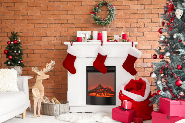Interior de la sala de estar con bolsa de Santa, chimenea y árbol de Navidad - Foto, imagen