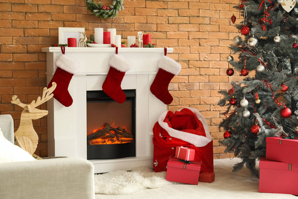 Interior de la sala de estar con bolsa de Santa, chimenea y árbol de Navidad - Foto, imagen