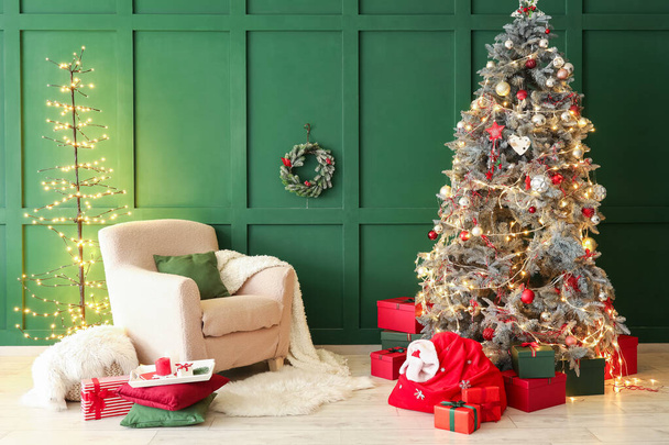 サンタバッグ、アームチェア、クリスマスツリー付きのリビングルームのインテリア - 写真・画像