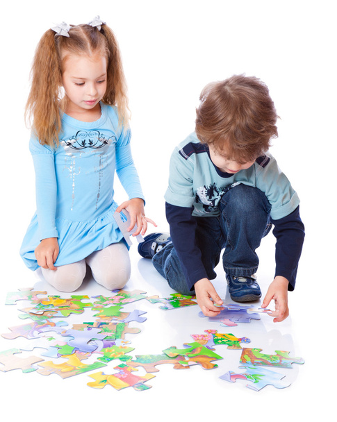 Boy and girl are playing with puzzle - Foto, afbeelding