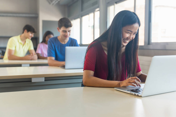 Asiática adolescente estudante trabalhando com laptop na escola - Foto, Imagem