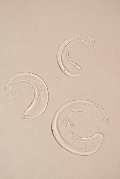Producto de belleza. Mancha de gel de aloe vera cosmética transparente, mancha sobre fondo beige pastel neutro - Foto, imagen