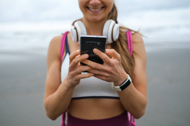 Sağlıklı fitness ya da müzik akıllı telefonu kullanan sportif bir kadının ayrıntıları - Fotoğraf, Görsel