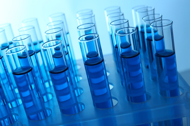Blue water in a transparent test-tube on light background - Φωτογραφία, εικόνα