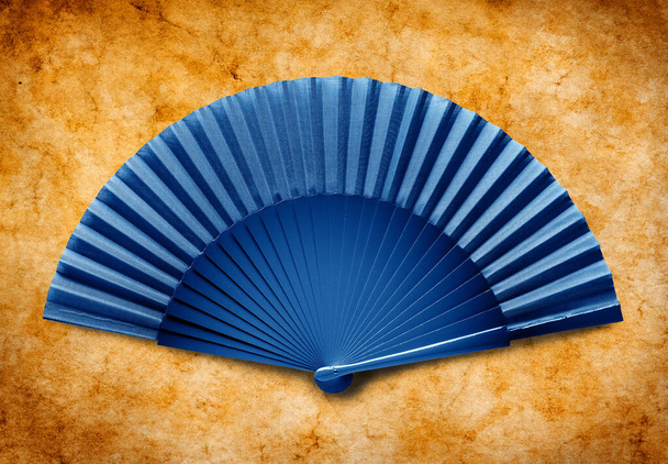 голубой ручной вентилятор на теплой поверхности пергамента - Фото, изображение
