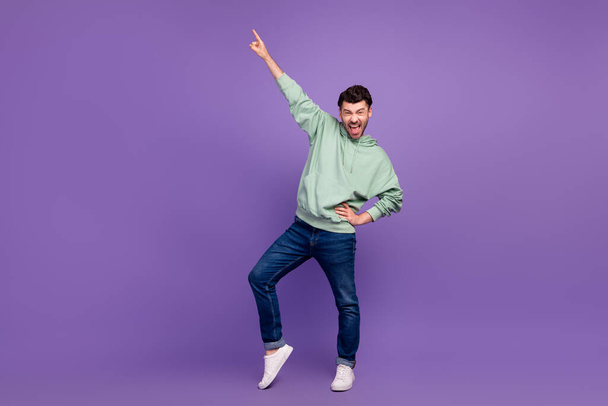 Full body size photo of young crazy excited man bearded wear stylish oufit touch waist finger point up positive isolated on bright violet color background. - Φωτογραφία, εικόνα