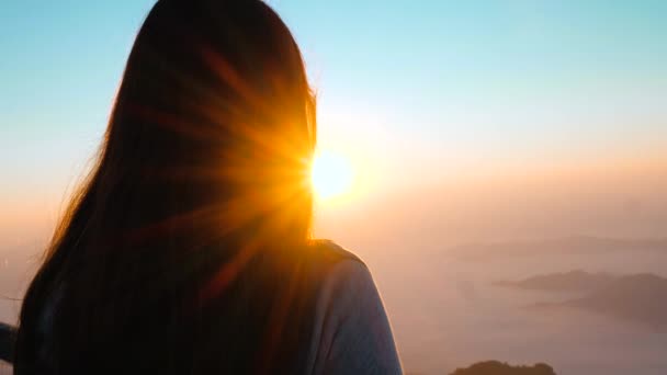 Umut dolu kadın dağın yanındaki günbatımına bakıyor. Motivasyonun silueti Ufukta umutlu görünen bir hayalperest kızı hissetmek. - Video, Çekim