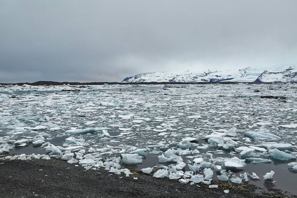 Glacial lake in Jokulsarlon with floating icebergs, gloomy weather - Foto, Imagem