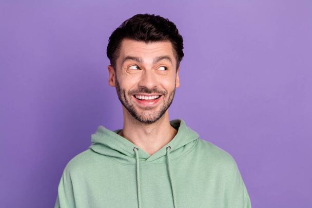 Closeup photo of young funny excited man bearded toothy smile dreamy look interested information empty space isolated on violet color background. - Фото, изображение