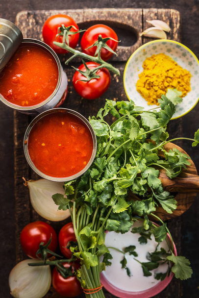 Close up of fresh organic ingredients for tasty cooking: fresh herbs,spices can with passed tomatoes. Top view. Copy space. Healthy vegetarian homemade food - Foto, Imagen