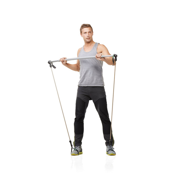 Fitness is his goal. A young man using a resistance band to tone his body - Photo, image