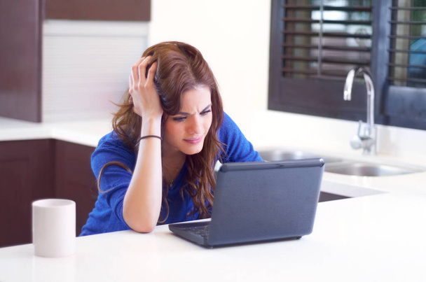 Langsame Internetverbindungen. Eine junge Frau sieht frustriert aus, während sie an ihrem Laptop arbeitet - Foto, Bild