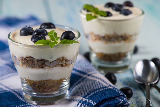 Glass with muesli creamy yogurt and fresh blueberries - Photo, Image