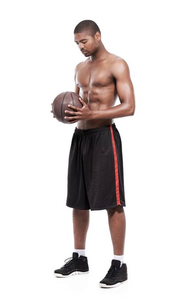 Contemplating his basketball future. A handsome young basketball player standing shirtless in the studio - Fotografie, Obrázek