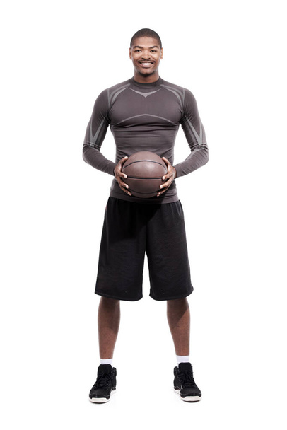 У нього пристрасть до баскетболу. Портрет красивого молодого баскетболіста, що стоїть в студії
 - Фото, зображення