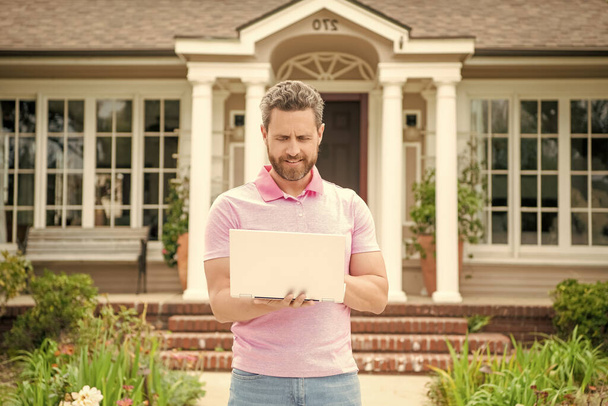 hombre barbudo ocupado agente inmobiliario comprar casa en línea en el ordenador portátil, hipoteca. - Foto, imagen