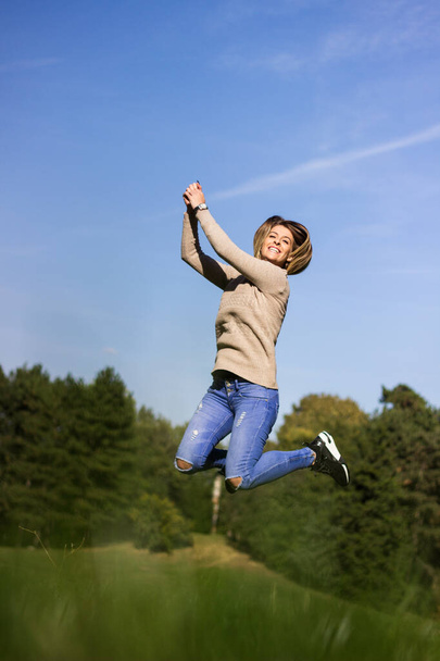 Mujer feliz saltando en la naturaleza - Foto, imagen