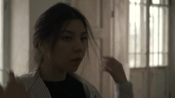 Ázsiai gyönyörű fiatal nő megérinti a haját, boldogtalannak érzi magát, szenved az élet zavaros. Filmművészeti stílusban forgatva - Felvétel, videó