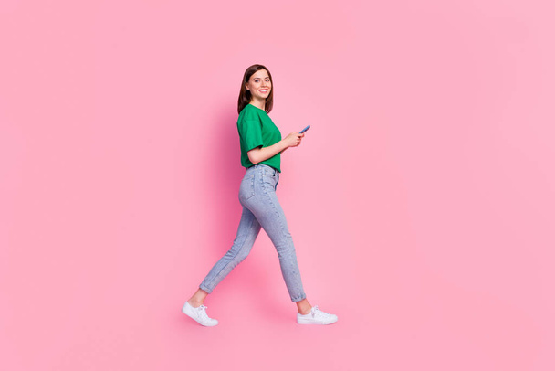 Full size profile photo of cheerful nice girl hold use telephone walking isolated on pink color background. - Fotografie, Obrázek