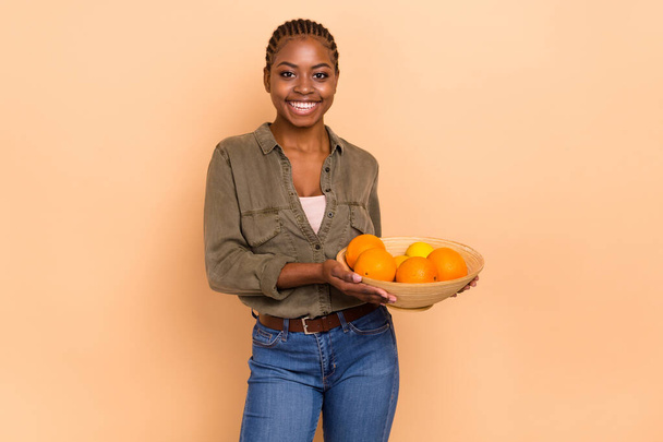Photo of cheerful person hands hold oranges bowl have good mood isolated on beige color background. - Photo, Image